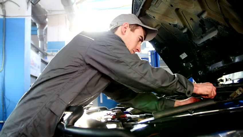 Technician showing a customer the underside of her car